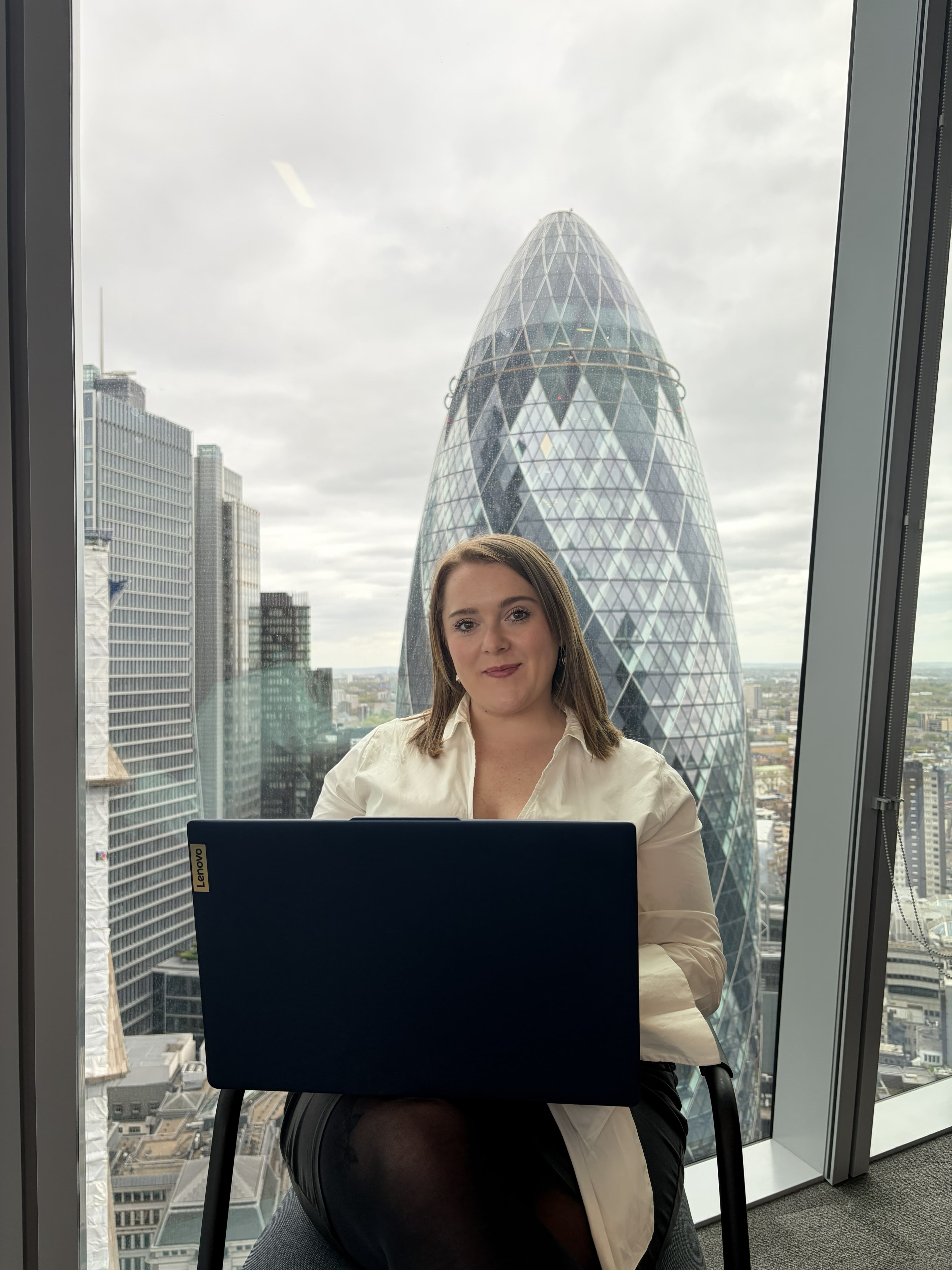 Chloe Wallace, founder of OneSource HR, working with the City of London skyline behind her